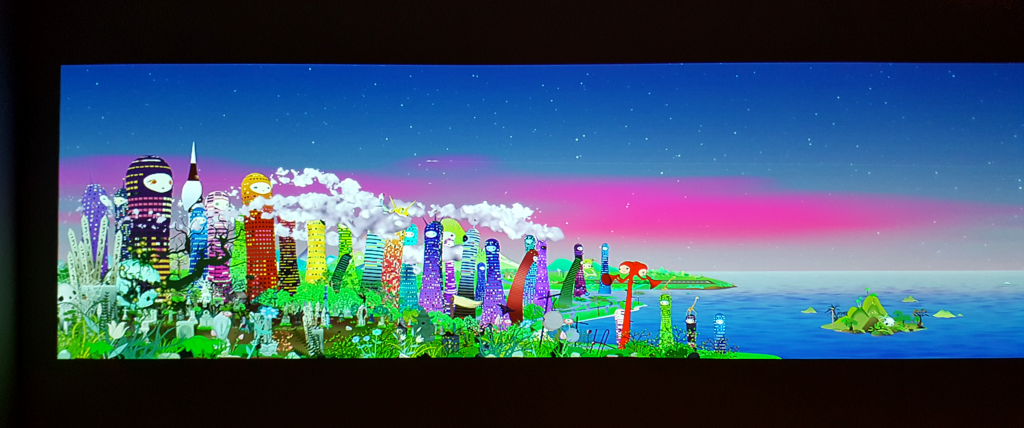 Chiho Aoshima Takaamonohara freeze frame of a colorful city of anthropomorphic buildings against a bright, highly saturated blue and pink sky.