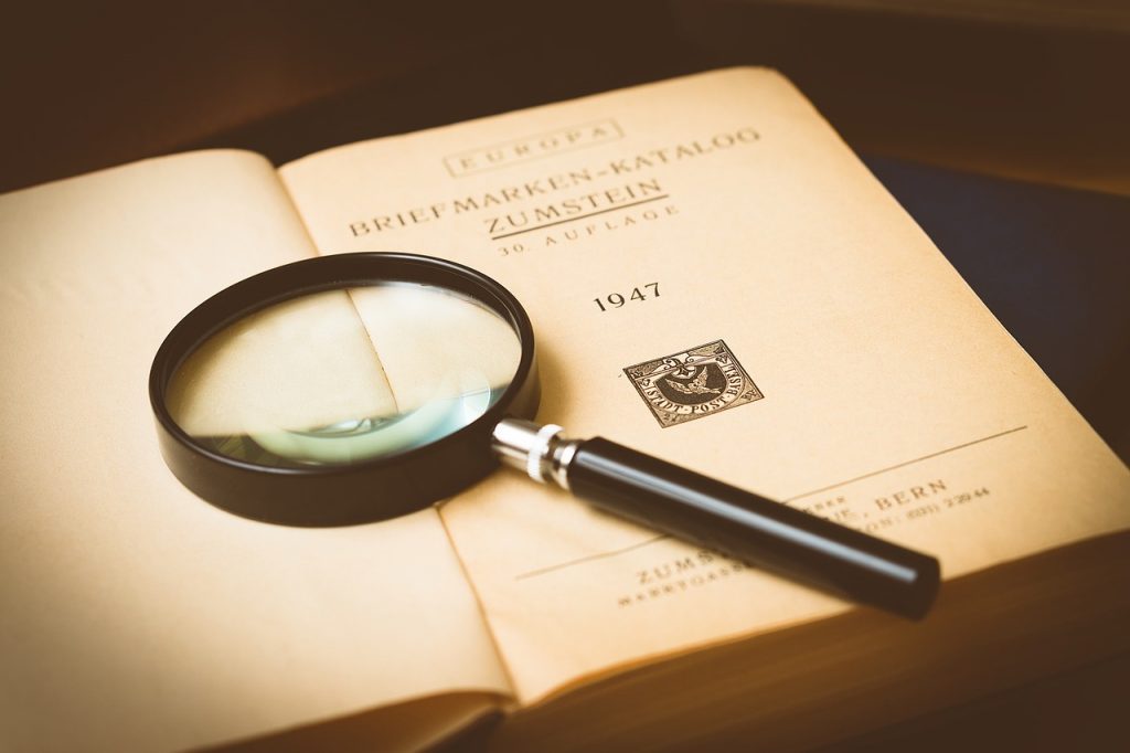 Necessary Preorders: magnifying glass on old book